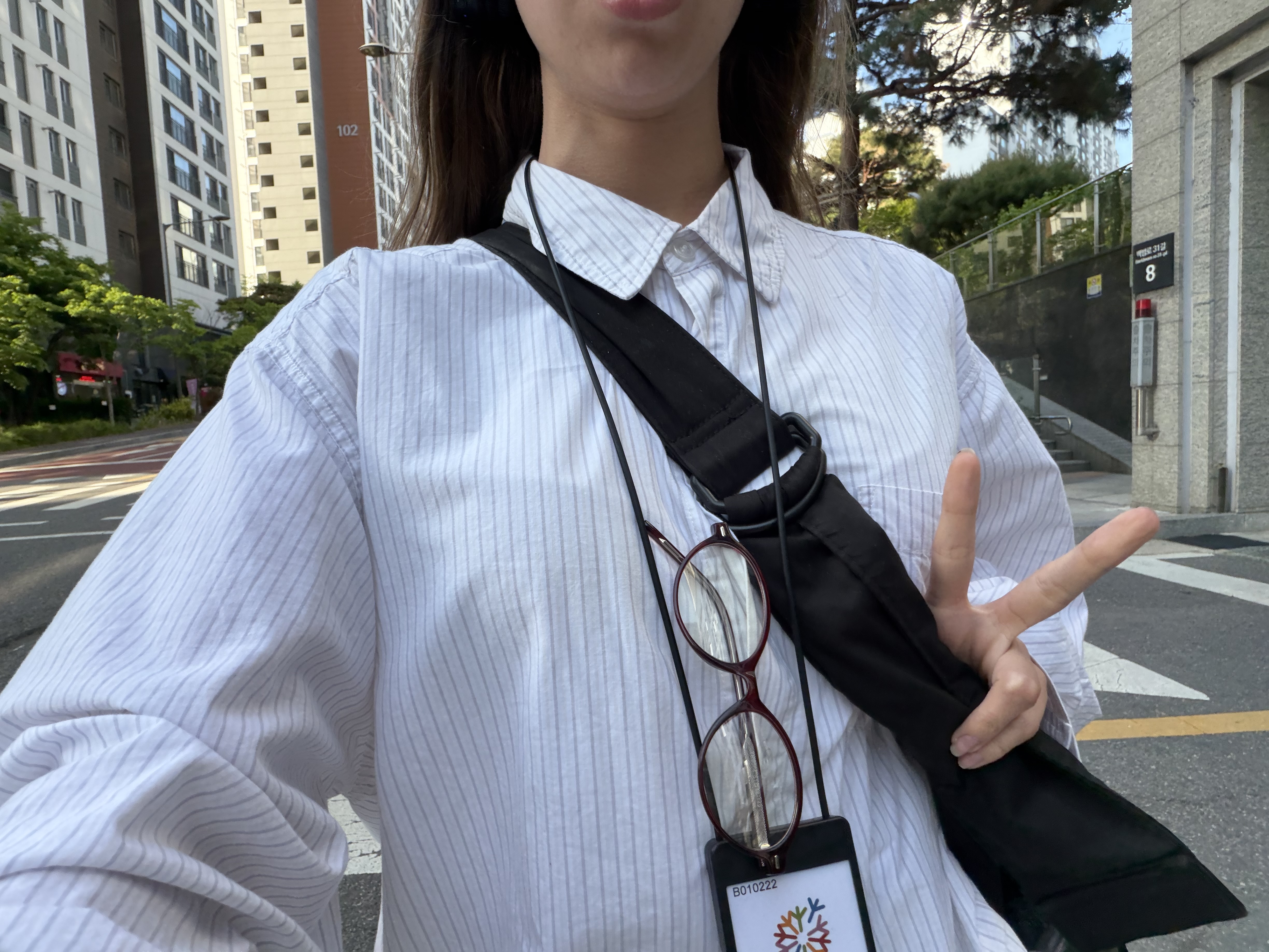 A selfie of a young woman making the peace sign with her fingers.