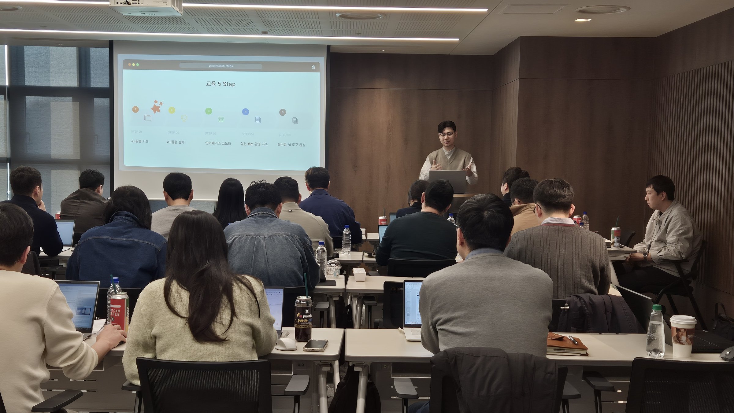 임직원 AI 교육 현장에서 강사가 교육 5단계 슬라이드를 설명하는 모습