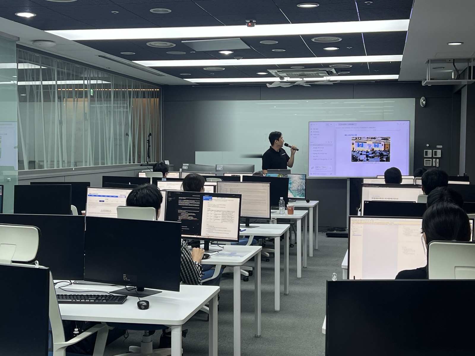 대구경북디자인센터 교육실에서 마이크를 들고 설명하는 주강사와 NIA 10월 AI 활용교육 수강생들