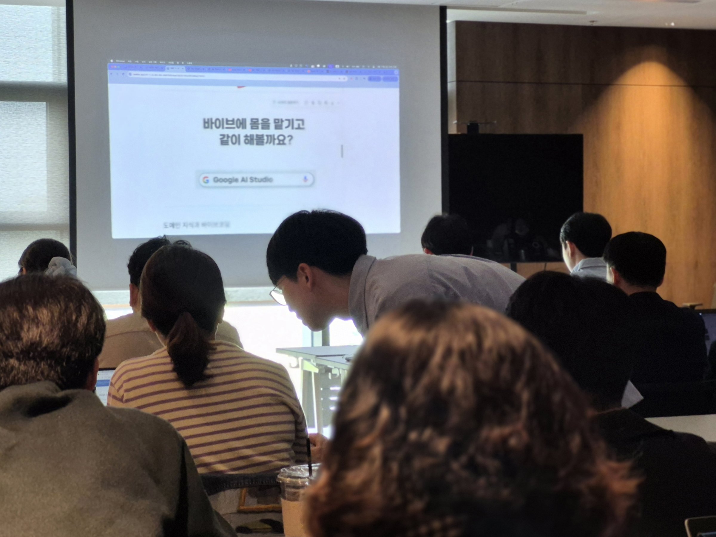 비개발자 대상 AI 교육에서 강사가 참가자 자리로 가서 개별 지도하는 모습