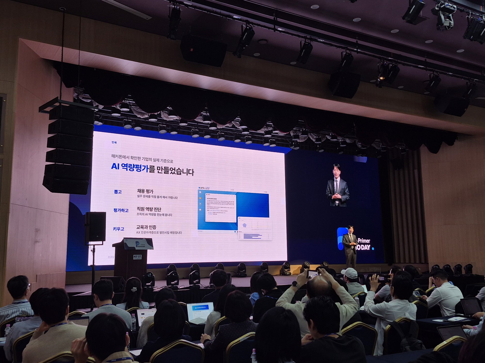 해커톤에서 확인한 기업의 실제 기준으로 AI 역량평가를 만들었다는 슬라이드를 발표하는 무대